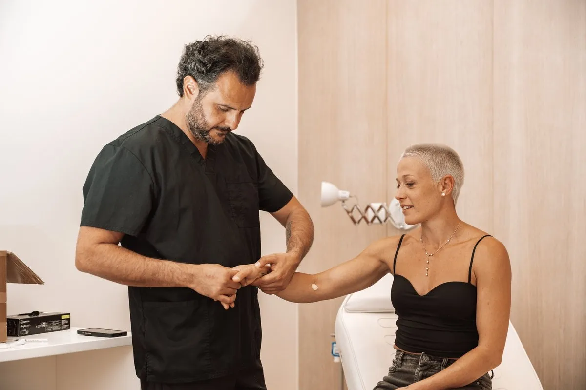 Dr. Arvin Yarollahi examining a patient's hand and wrist at CellOrtho Marbella