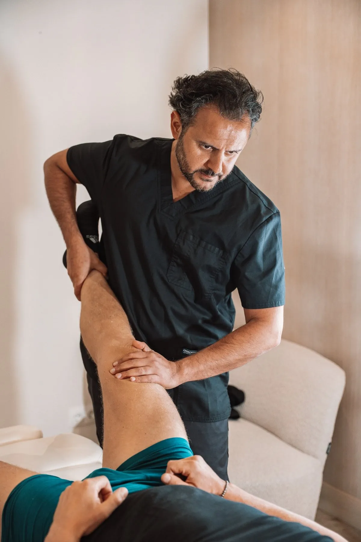 Dr. Arvin Yarollahi examining a patient's knee at CellOrtho Marbella