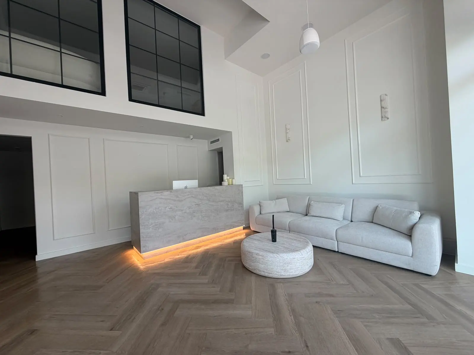Reception area with travertine desk and herringbone flooring